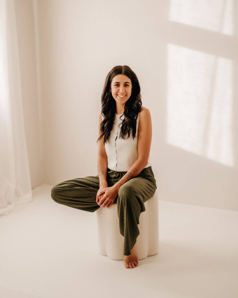 Lisa Schuler sitzt ruhig auf einem Hocker im SoulStudio.